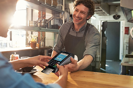 Cashier accepts payment from a customer in delicatessen